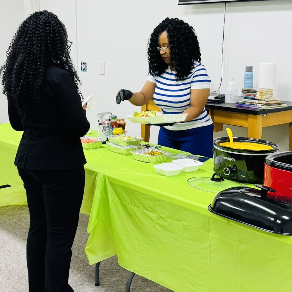A woman serving food to a girl.